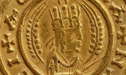 Obverse of coin with half-length bust of Ezanas right, crowned, holding a stick or scepter, flanked by two wheat-stalks, the whole in a beaded circle with Greek lettering around the outside.