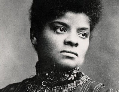 A portrait of Ida B. Wells. She is wearing a striped, high-necked dress and her hair is in a bun.  